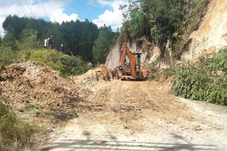 Alat berat digunakan untuk mengangkat material longsor yang menimbun jalan provinsi di Taput, Rabu (20/12/2023)