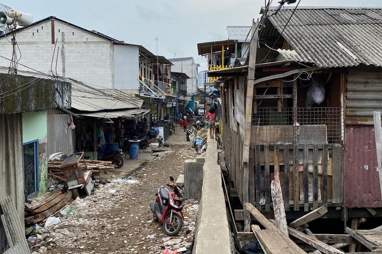 Jalan di kampung apung Muara Baru, Penjaringan, Jakarta Utara hanya bisa dilalui satu orang saja. Mereka harus bergantian menggunakan jalan setapak itu jija berpapasan dengan warga lainnya, Jumat (27/1/2023). 