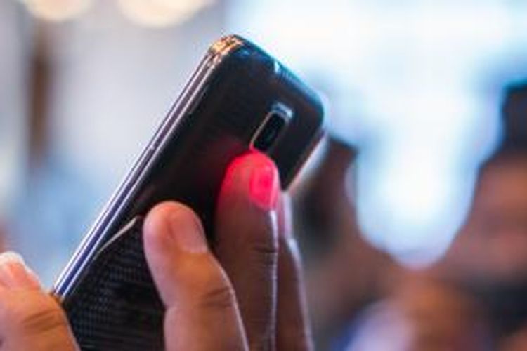 Sensor detak jantung di punggung Galaxy S5 menyala merah ketika mendeteksi detak jantung lewat jari pengguna