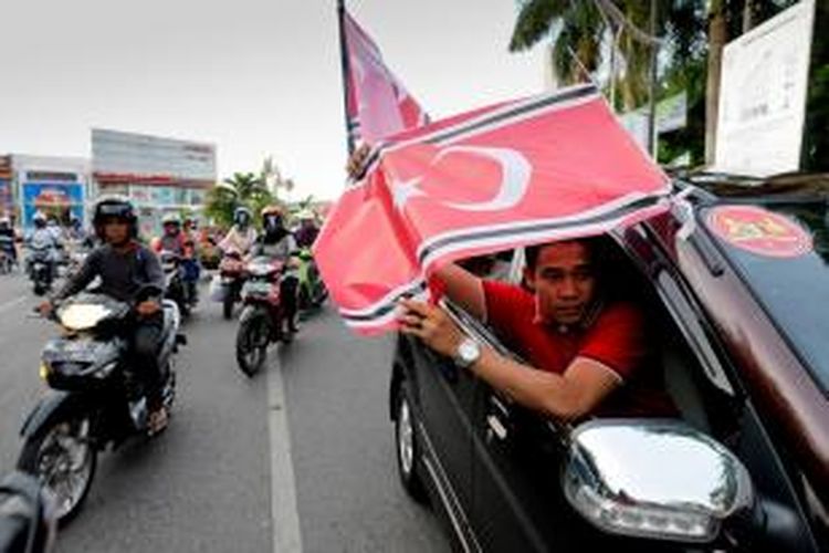 Warga dari Kabupaten Nagan Raya konvoi sambil mengibarkan Bendera Bintang Bulan di seputaran Kota Banda Aceh, Selasa (26/3/2013). Sejak 25 Maret 2013, Pemerintah Aceh telah menetapkan dan mengundangkan dalam lembaran daerah bendera dan lambang Gerakan Aceh Merdeka (GAM) sebagai lambang dan bendera daerah.  