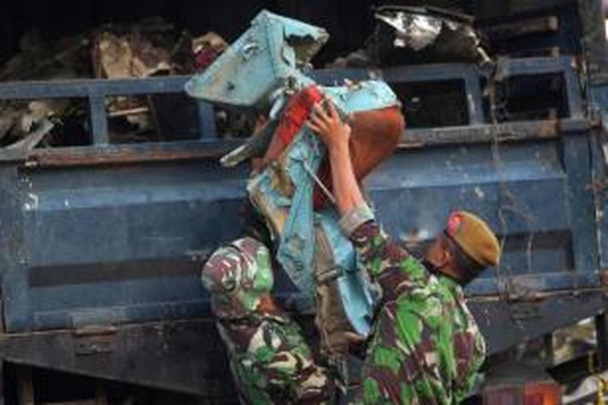 Anggota TNI memasukkan kursi pesawat yang ditemukan di antara puing pesawat Hercules C-130 TNI AU, 1 Juli 2015. Pesawat Jatuh pada Selasa di Jalan Jamin Ginting, Medan, dua menit setelah lepas landas dari Pangkalan Udara Soewondo pukul 12.08.