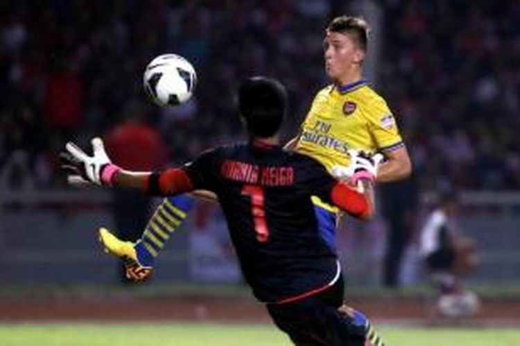 Pemain Arsenal, Gedion Zelalem (belakang) beadu dengan kiper Indonesia Dream Team, Kurnia Meiga dalam laga persahabatan di Stadion Utama Gelora Bung Karno, Jakarta, Minggu (14/7/2013). Indonesia dicukur habis oleh Arsenal 0-7.