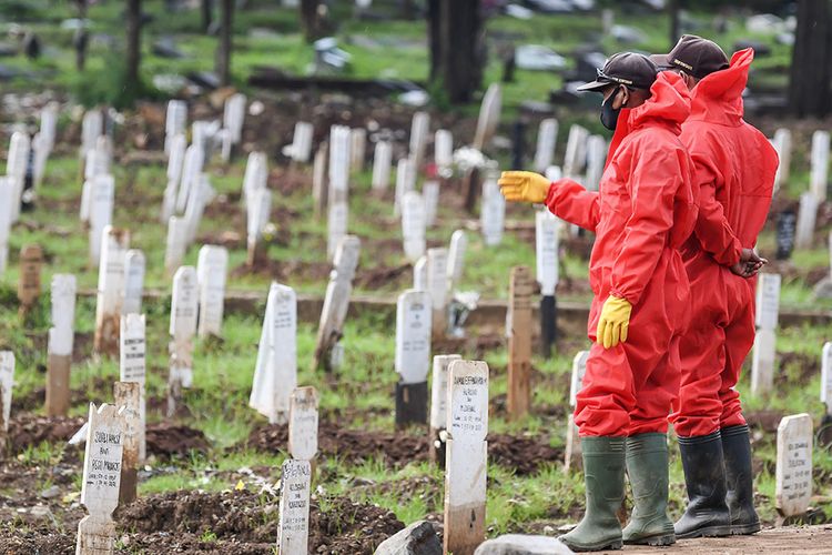 Dua orang petugas menghitung jumlah makam di pemakaman khusus dengan protokol Covid-19 di TPU Bambu Apus, Jakarta Timur, Selasa (2/3/2021). Menurut Kepala Dinas Pertamanan dan Hutan Kota Provinsi DKI Jakarta Suzi Marsitawati, dua blok atau blad TPU Bambu Apus telah penuh terisi oleh 1.050 jenazah yang meninggal dunia akibat menderita Covid-19.