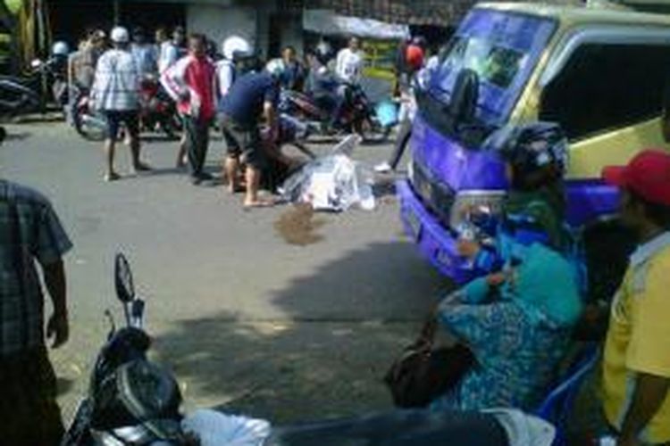 Jenazah Tegar, seorang pelajar tengah diangkat warga di Jalan Cendrawasih, Kelurahan Gebang, Kecamatan Patrang, Jember, Jawa Timur. Ia tewas setelah terjatuh dan terlindas seusai pulang sekolah, Kamis (24/10/13).