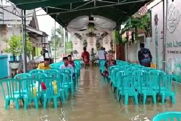 Pesta pernikahan di Sumenep digelar di tengah banjir. 