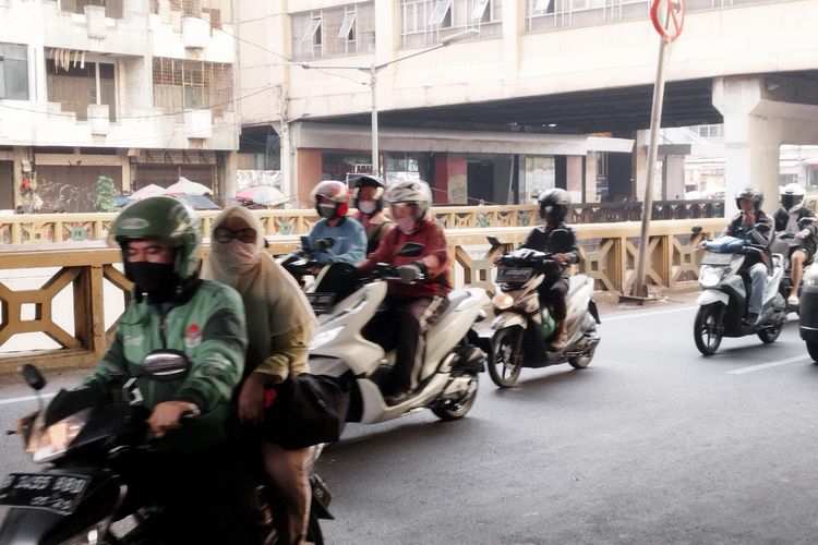 Pembonceng motor (kiri) tak menggunakan helm di Jalan KH Mas Mansyur, Tanah Abang, Jakarta Pusat, Senin (13/11/2023). (KOMPAS.com/XENA OLIVIA)