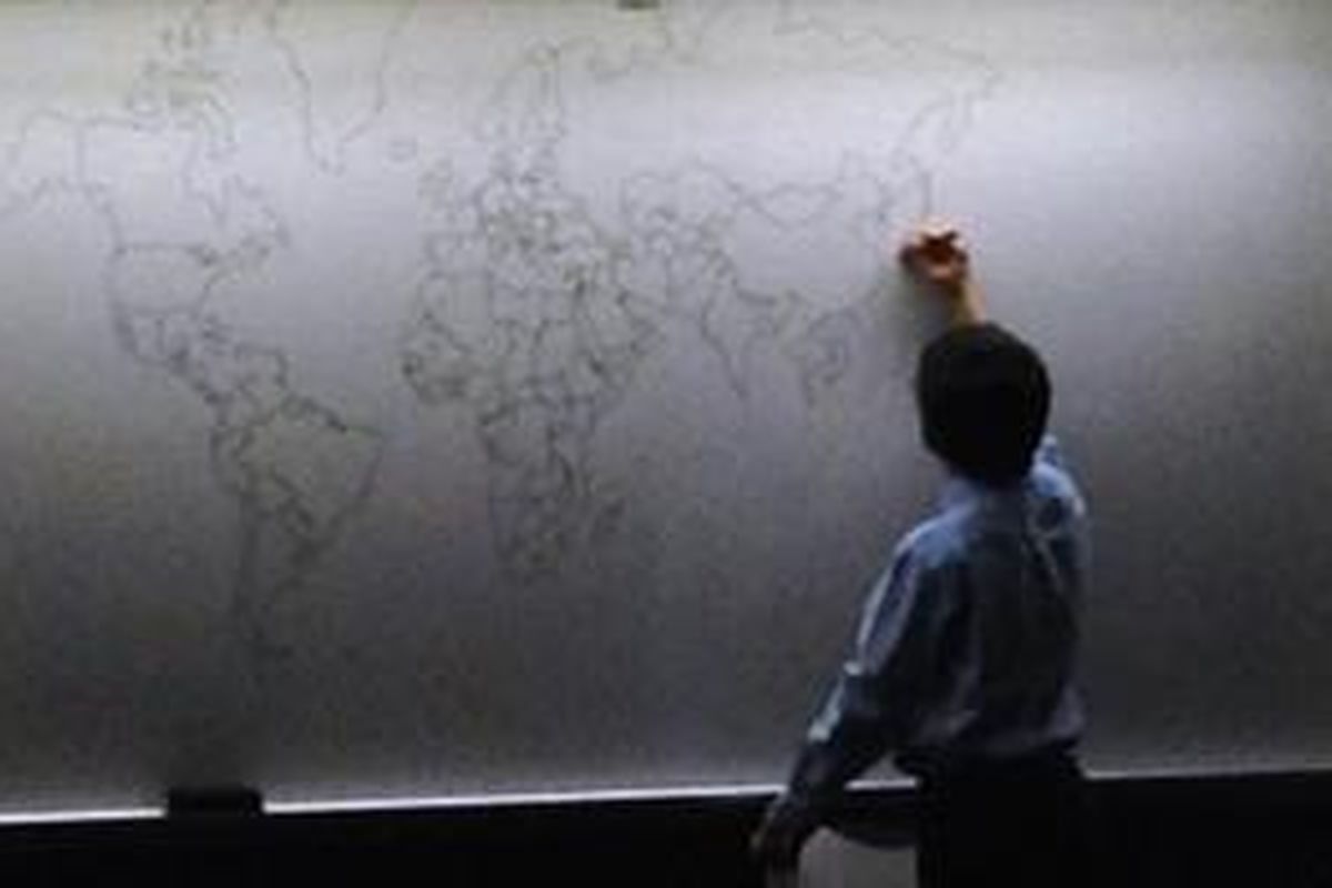 Sebuah foto yang diungah ke dunia maya, memperlihatkan sang bocah sedang menggambar peta dunia. 