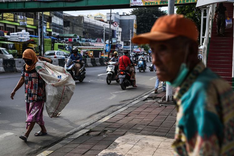 Tunawisma menggunakan masker saat berjalan di Jl. K.H. Mas Mansyur, Jakarta Pusat, Senin (4/5/2020). Provinsi DKI Jakarta memasuki pelaksanaan pembatasan sosial berskala besar (PSBB) yang diperpanjang ke tahap kedua. Tujuan PSBB ini adalah untuk menekan penyebaran virus corona (Covid-19).