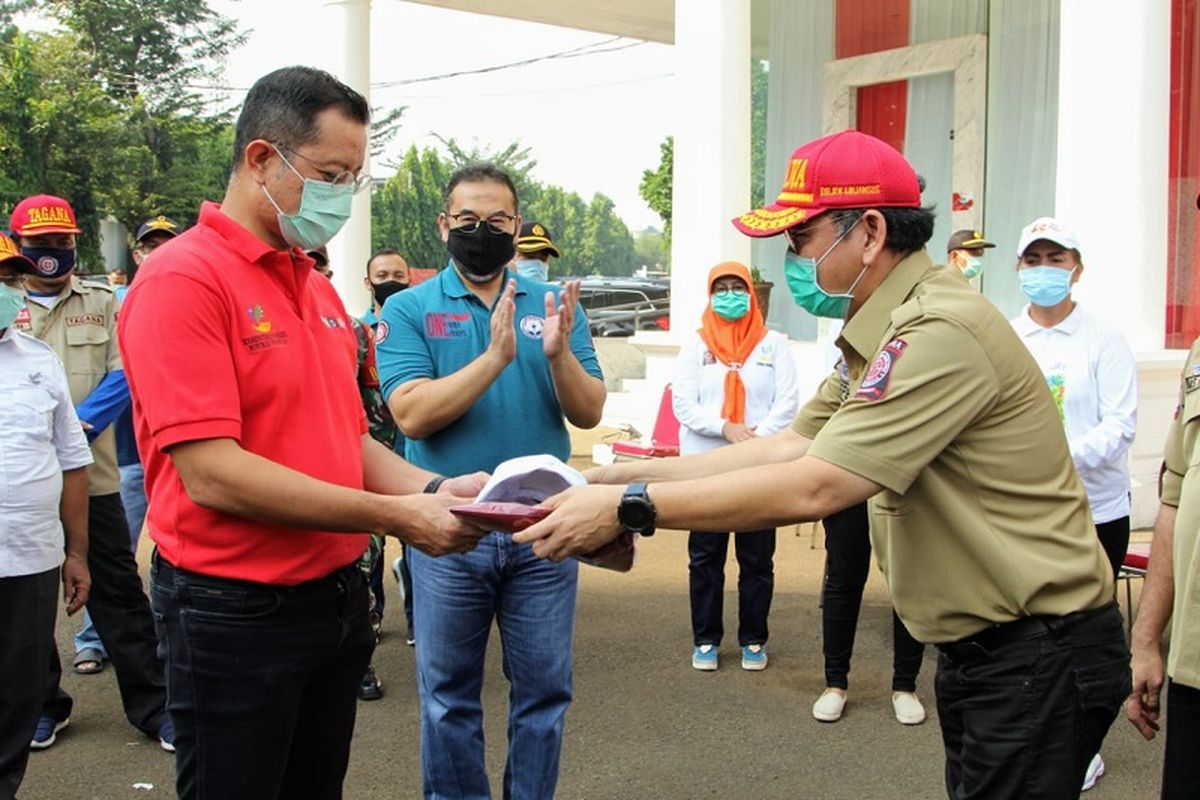 Menteri Sosial Juliari P. Batubara menyerahkan cinderamata kepada perwakilan Taruna Siaga Bencana (Tagana), di halaman Gedung Konvensi di Gedung Konvensi Kompleks Taman Makam Pahlawan Nasional Utama (TMPNU) Kalibata, Jakarta (19/04/2020). 