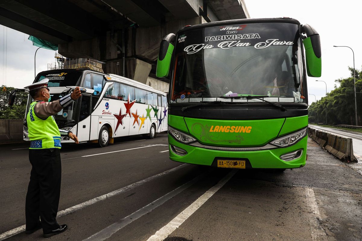 Polisi menghalau mobil bus yang membawa penumpang di jalan tol Jakarta-Cikampek untuk keluar ke Gerbang tol Cikarang Barat, Kabupaten Bekasi, Jawa Barat, Jumat (24/4/2020). Larangan mudik mulai diberlakukan 24 April 2020 pukul 00.00 WIB. Polda Metro Jaya melarang kendaraan pribadi baik motor atau mobil dan kendaraan umum berpenumpang keluar dari wilayah Jabodetabek. Pemeriksaan dan penyekatan kendaraan tersebut akan dilakukan di 18 titik pos pengamanan terpadu dan pos-pos check point di jalur tikus dan perbatasan.