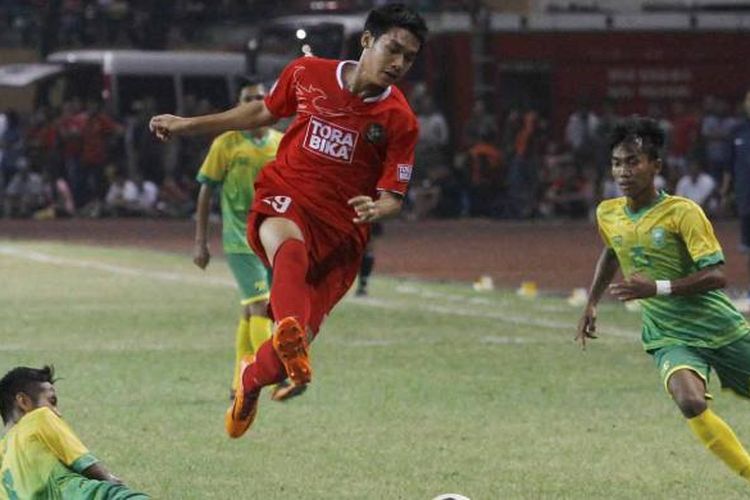 Striker Timnas U-19 Septian David Maulana melompat menghindari hadangan pemain tim Pra-Pon Riau Novrianto pada laga Tur Nusantara Timnas U-19, Senin (16/6/2014) di Stadion Utama Riau, Pekanbaru. Timnas U-19 berhasil melibas tuan rumah Riau dengan skor 4-0.  