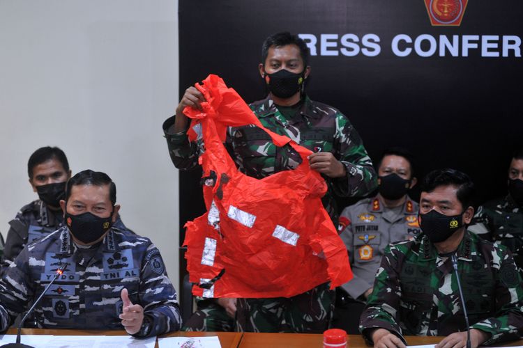 Panglima TNI Marsekal TNI Hadi Tjahjanto (kanan) dan Kepala Staf Angkatan Laut Laksamana TNI Yudo Margono (kiri) menunjukkan baju keselamatan awak kapal KRI Nanggala 402 yang ditemukan saat konferensi pers di Lanud I Gusti Ngurah Rai, Badung, Bali, Minggu (25/4/2021). KRI Nanggala 402 dipastikan tenggelam dan 53 awak kapalnya gugur di perairan utara Bali. ANTARA FOTO/Fikri Yusuf