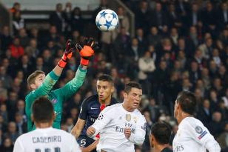 Pemain depan Real Madrid, Cristiano Ronaldo (kedua dari kanan), melakoni duel udara dengan penjaga gawang Paris Saint-Germain, Kevin Trapp (kiri) ketika kedua tim bertemu pada lanjutan Liga Champions di Stadion Parc des Princes, Rabu (21/10/2015).