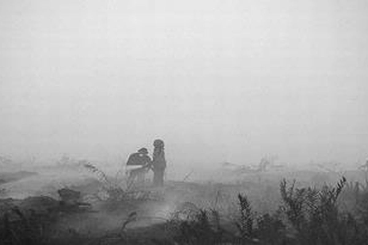 Kebakaran lahan menyelimuti kawasan perkebunan sawit di Desa Seponjen, Kecamatan Kumpeh Ilir, Kabupaten Muaro Jambi, Jambi, Minggu (4/9/2011). Tingginya pergerakan angin mempermudah penyebaran api di lahan gambut ini. Petugas Manggala Agni tengah memadamkan kebakaran.