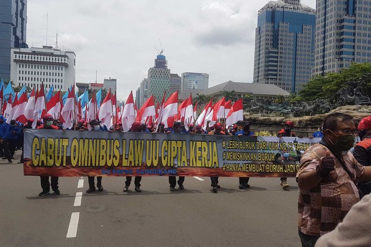 Massa Buruh Membawa spanduk yang menyerukan penolakan pada Omnibus Law UU Cipta kerja, pada aksi unjuk rasa, Senin (2/11/2020) di sekitar Patung Kuda Arjuna Wiwaha, Jakarta Pusat.