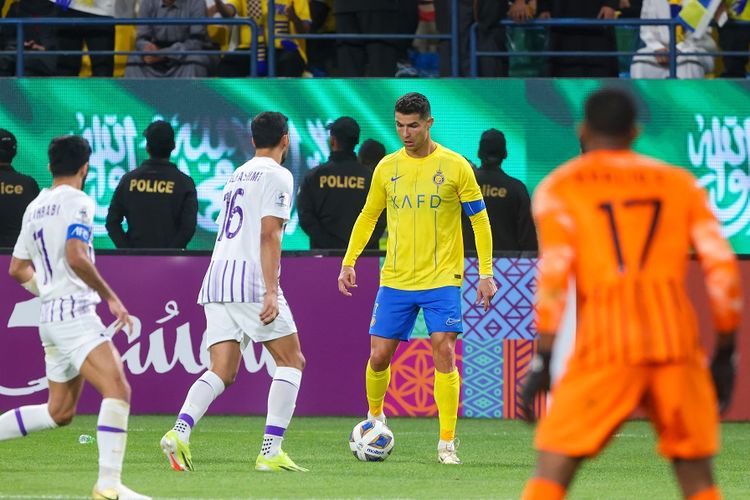 Penyerang Al Nassr Cristiano Ronaldo (kuning) terlihat menjaga bola selama pertandingan sepak bola Liga Champions Asia antara Al-Nassr vs Al-Ain di Stadion Al-Awal Park di Riyadh pada 11 Maret 2024.