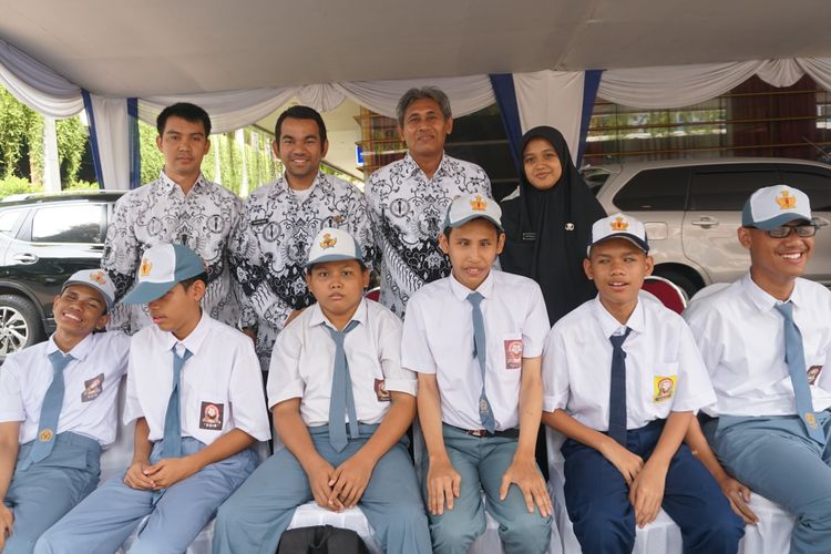 Ajar Agus Budianto (belakang kedua dari kanan), guru SLB A Pembina Jakarta bersama murid dan guru SLB A Pembina lainnya saat menghadiri upacara Hari Guru Nasional 2019 di Kementerian Pendidikan dan Kebudayaan, Jakarta, Senin (25/11/2019). Budi telah menjadi guru SLB khususnya untuk penyandang tuna netra sejak tahun 1998. 