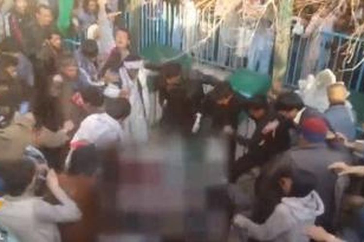 Dalam foto yang diambil dari video yang disiarkan stasiun televisi 1TV Kabul, Afganistan terlihat massa yang marah menyerang seorang perempuan hingga tewas. Motif penyerangan itu diduga karena perempuan tersebut diketahui membakar sebuah Al Quran.