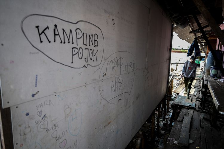 Seorang warga berjalan di titian rumahnya di Kampung Pojok, Kecamatan Penjaringan, Jakarta, Senin (5/2/2024). Pemerintah menargetkan angka kemiskinan ekstrem di Indonesia menjadi 0 persen pada 2024, setelah mengalami penurunan 1,12 persen pada 2023. 