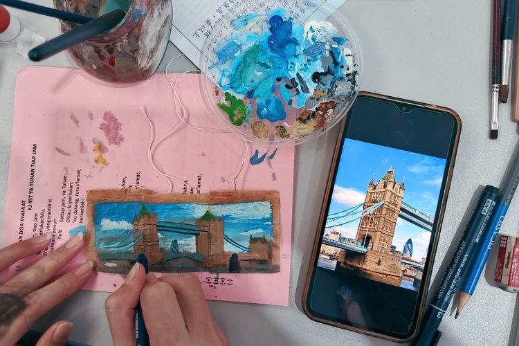 Salah satu Mahasiswa Ubaya sedang melukis menggunakan media kantong teh bekas untuk memperingati hari teh sedunia yang jatuh setiap tanggal 21 Mei.