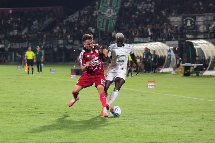 Gelandang Bali United, Queven da Silva, terlibat perebutan bola dengan pemain PSS Sleman, Moussa Bagayoko