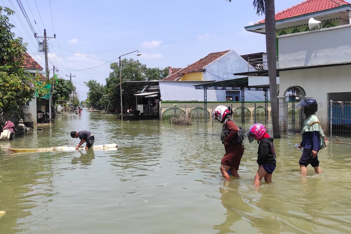 TERJANG BANJIR: Sejumlah warga di Dukuh Kedung Banteng, Desa Wonorejo, Kecamatan Karanganyar, Kabupaten Demak tampak menerobos banjir untuk menengok rumah, Rabu (27/3/2024). 