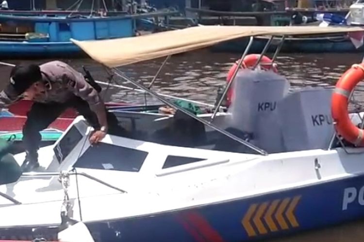 Seorang personel kepolisian memasukkan kotak suara ke speedboat untuk dikirim ke Desa Tanjung Saleh, Kakap, Kubu Raya, Kalimantan Barat, Selasa (16/4/2019).