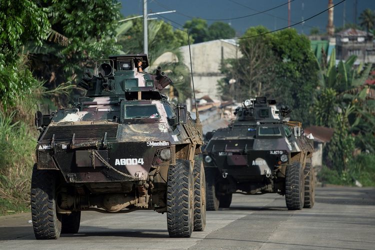 Sejumlah kendaraan lapis baja dari pasukan pemerintah melintas di sebuah perkampungan di Kota Marawi, Filipina, Minggu (4/6/2017). Pertempuran berdarah terjadi antara militer Filipina dengan pasukan Maute di Marawi dalam upaya menangkap pemimpin kelompok Abu Sayyaf, Isnilon Hapilon.