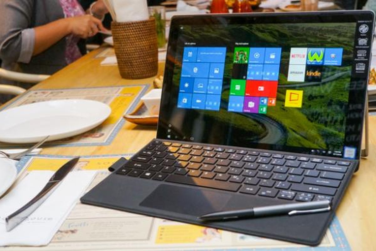 Tampak depan laptop 2-in-1 Acer Switch Alpha 12 berikut aksesori stylus dan keyboard yang terpasang di bagian bawah dengan engsel magnet.