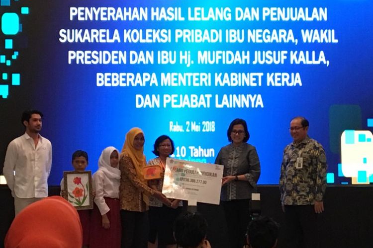 Menteri Keuangan Sri Mulyani Indrawati saat menyerahkan hasil lelang pejabat negara di gedung Jusuf Anwar, Kementerian Koordinator Bidang Perekonomian, Jakarta Pusat, Rabu (2/5/2018) malam. 