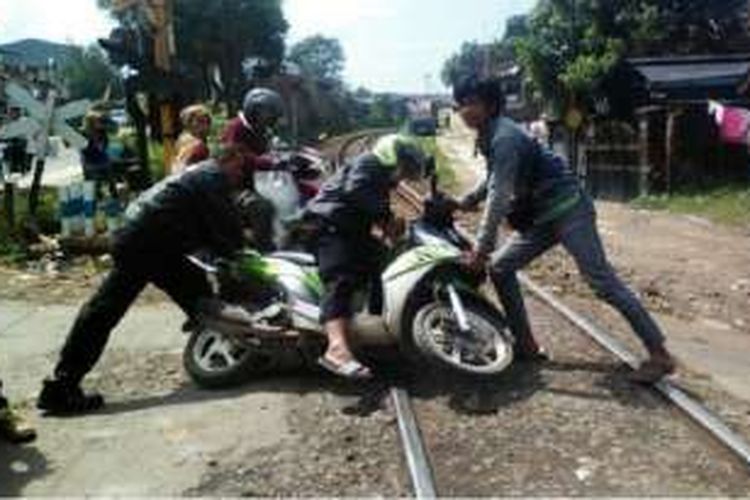 Salah seorang pengendra roda dua terjatuh saat melintasi jalan perlintasan rel kereta api tepatnya di Kampung Cikuya, Desa Cicalengka Kulon, Kecamatan Cicalengka, Kabupaten Bandung, Minggu (27/3/2016). 