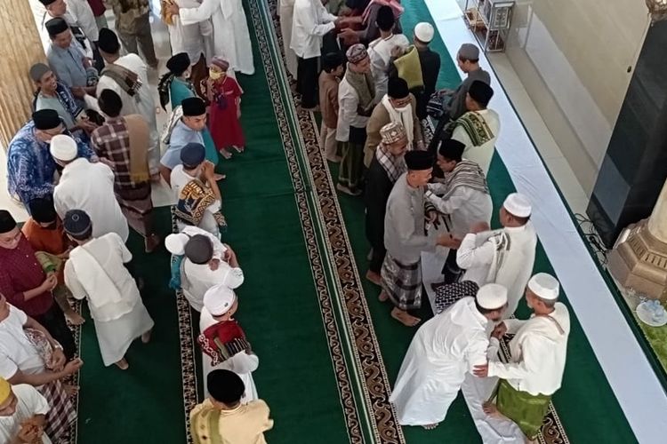 Warga saling bersalam SALAMAN usai menjalani shalat Id di Masjid Nurul Huda, Taman Sari Mataram, Senin (1/5/2022).