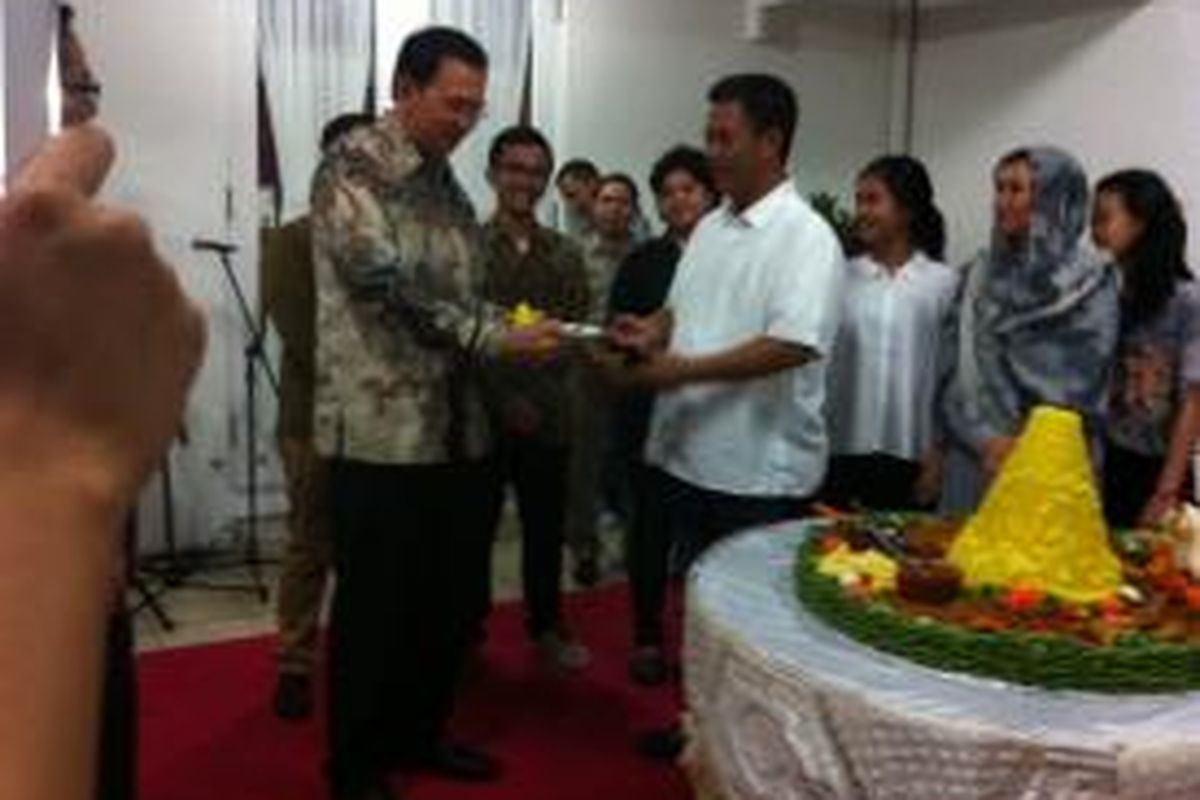 Gubernur DKI Jakarta Basuki Tjahaja Purnama menerima potongan tumpeng pertama dari Ketua DPRD Prasetyo Edi Marsudi di Jakarta, Rabu (26/11/2014).