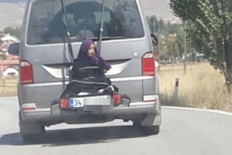 Tangkapan layar rekaman video seorang anak perempuan yang terikat pada bagian belakang mobil yang melaju di Turki.