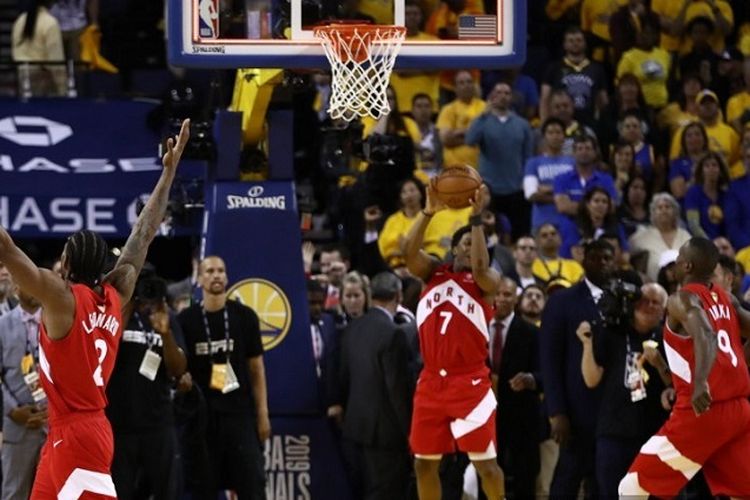 Pemain Toronto Raptors Kawhi Leonard (kiri), Lowry (tengah), dan Ibaka (kanan) merayakan kemenangan timnya atas Golden State Warriors pada babak final NBA 2019 di Oracle Arena pada 13 Juni 2019 di Oakland, California.
