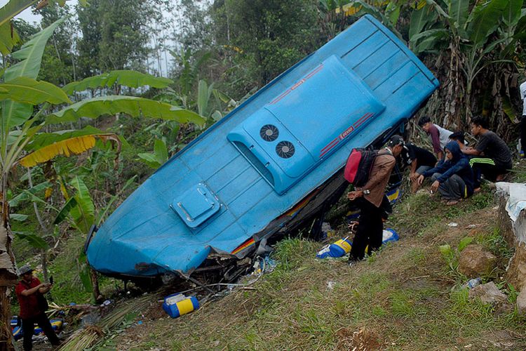 Sejumlah warga melihat sebuah bus berpenumpang wisatawan yang masuk jurang di Tanjakan Letter S, Cikidang, Sukabumi, Jawa Barat, Sabtu (8/9/2018). Data Polres Sukabumi menyebutkan kecelakaan lalu lintas tunggal ini mengakibatkan 21 orang tewas dan 17 luka-luka berat dan ringan.