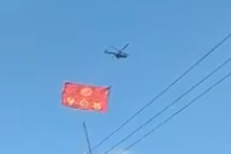 Tangkapan layar video bernarasi helikopter dibiarkan berkeliling untuk mengibarkan bendera China.