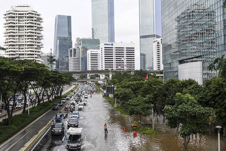 Sejumlah pengendara melintasi banjir di kawasan Jalan Jenderal Sudirman, Jakarta, Sabtu (20/2/2021). Intensitas hujan yang tinggi serta buruknya drainase menyebabkan banjir di sejumlah wilayah Ibu Kota.