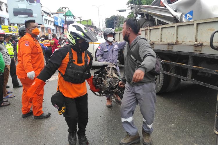 Petugas mengevakuasi kendaraan yang ditabrak truk dalam insiden laka maut Muara Rapak
