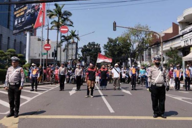 Polisi dan para pengguna jalan turun dari kendaraannya untuk memberikan hormat kepada Bendera Merah Putih saat detik-detik proklamasi. Video ini viral di media sosial dan direpost Dedi Mulyadi. 