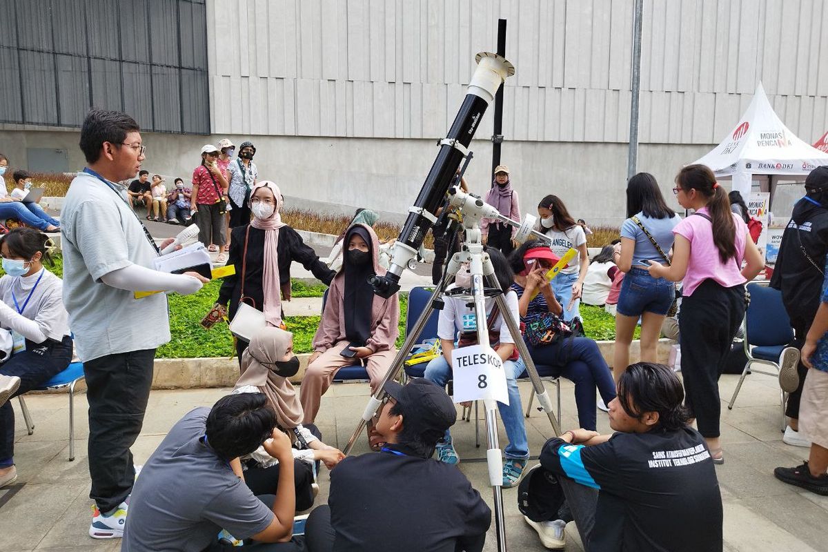 Sejumlah warga tampak antusias mendengarkan penjelasan panitia soal penggunaan teleskop yang digunakan untuk menyaksikan gerhana matahari hibrida di Taman Ismail Marzuki, Jakarta Pusat, pada Kamis (20/4/2023). (KOMPAS.com/XENA OLIVIA)