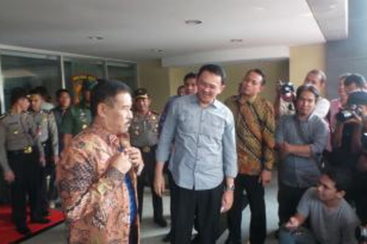 Gubernur DKI Jakarta Basuki Tjahaja Purnama saat memberikan batik kepada Manajer Persib Bandung Umuh Muchtar, di Mapolda Metro Jaya, Minggu (18/10/2015). 