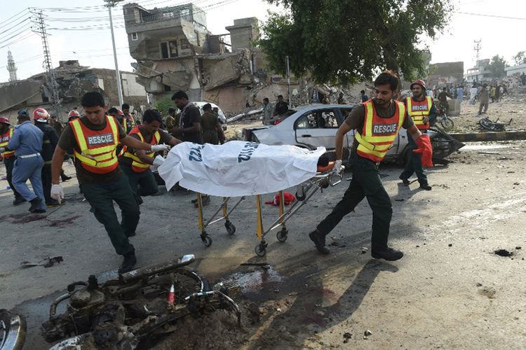 Para petugas penyelamat di Kota Lahore, Pakistan, bekerja memindahkan jasad para korban ledakan, Senin (24/7/2017).  