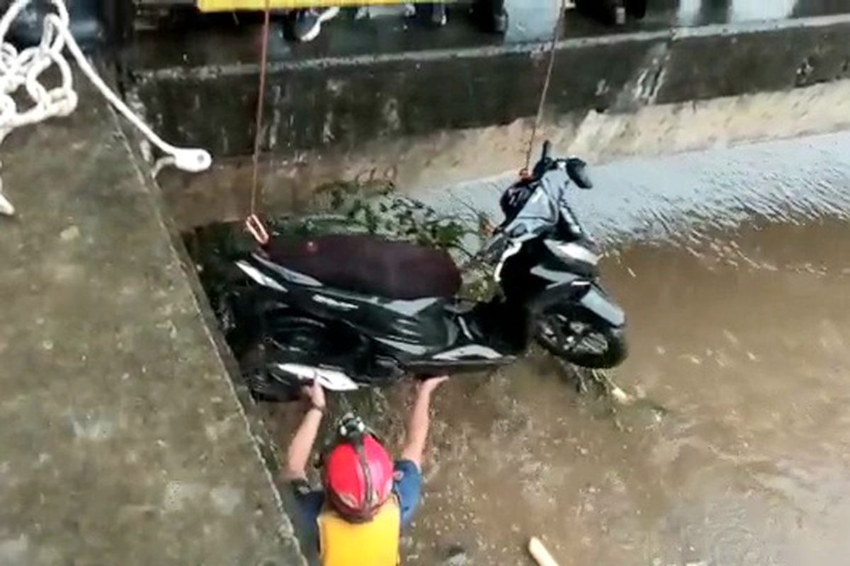 Seorang wanita berinisial P (21) beserta motor yang dikendarainya, tercemplung ke Kali Cengkareng Drain saat tengah berkendara di Jalan Kali Kapuk Timur, Kapuk, Cengkareng, Jakarta Barat, Kamis (13/10/2022) sore.
