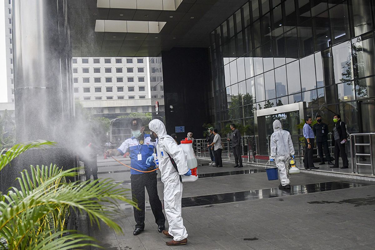 Petugas menyemprotkan cairan disinfektan di halaman Gedung KPK Merah Putih di Jakarta, Rabu (18/3/2020). Untuk mencegah penyebaran COVID-19, KPK melakukan disinfeksi di sejumlah area Gedung Merah Putih.