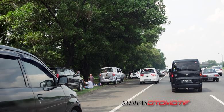 Macet parah bikin warga kelelahan, terlihat banyak mobil yang terparkir di pinggir jalan tol Jakarta-Cikampek, Kamis (7/7/2016). 