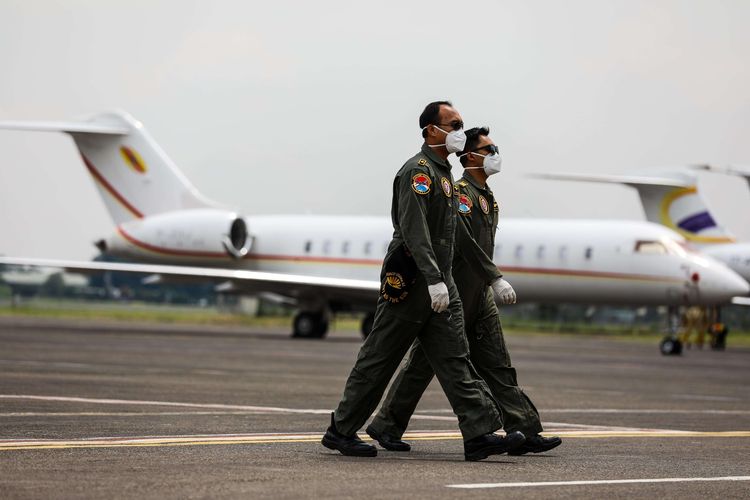 Kru pesawat TNI AU berjalan setelah tiba di Bandara Halim Perdanakusuma, Jakarta Timur, Senin (23/3/2020). Alat-alat kesehatan yang dibawa dari China untuk penanganan covid-19, yakni disposable mask, masker N95, APD, kacamata goggle, sarung tangan, pelindung sepatu, termometer infrared, dan lainnya.