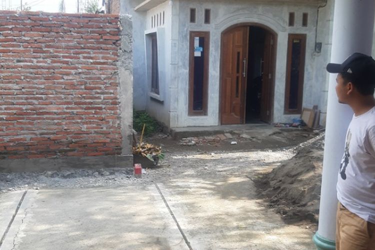 Tri Budi melihat tembok rumah yang menutup akses jalan di Desa Widodaren, Pemalang Jawa Tengah.