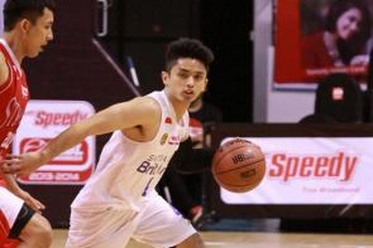 Pemain Satria Muda BritAma, Bayu Anggara (kanan), membawa bola melewati pemain Stadium pada pertandingan hari kedua turnamen pramusim National Basketball League (NBL) 2013, di DBL Arena Surabaya, Minggu (22/9/2013).