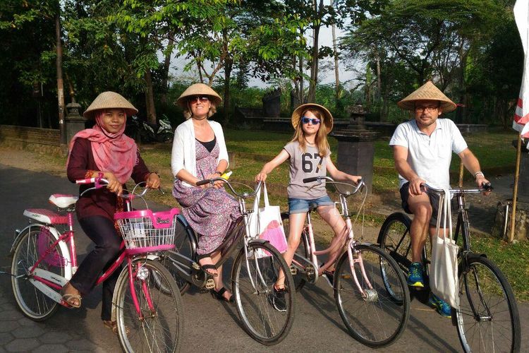 Seorang pemandu lokal sedang mengajak wisatawan jelajah kawasan Desa Wisata Candirejo di Magelang menggunakan sepeda.